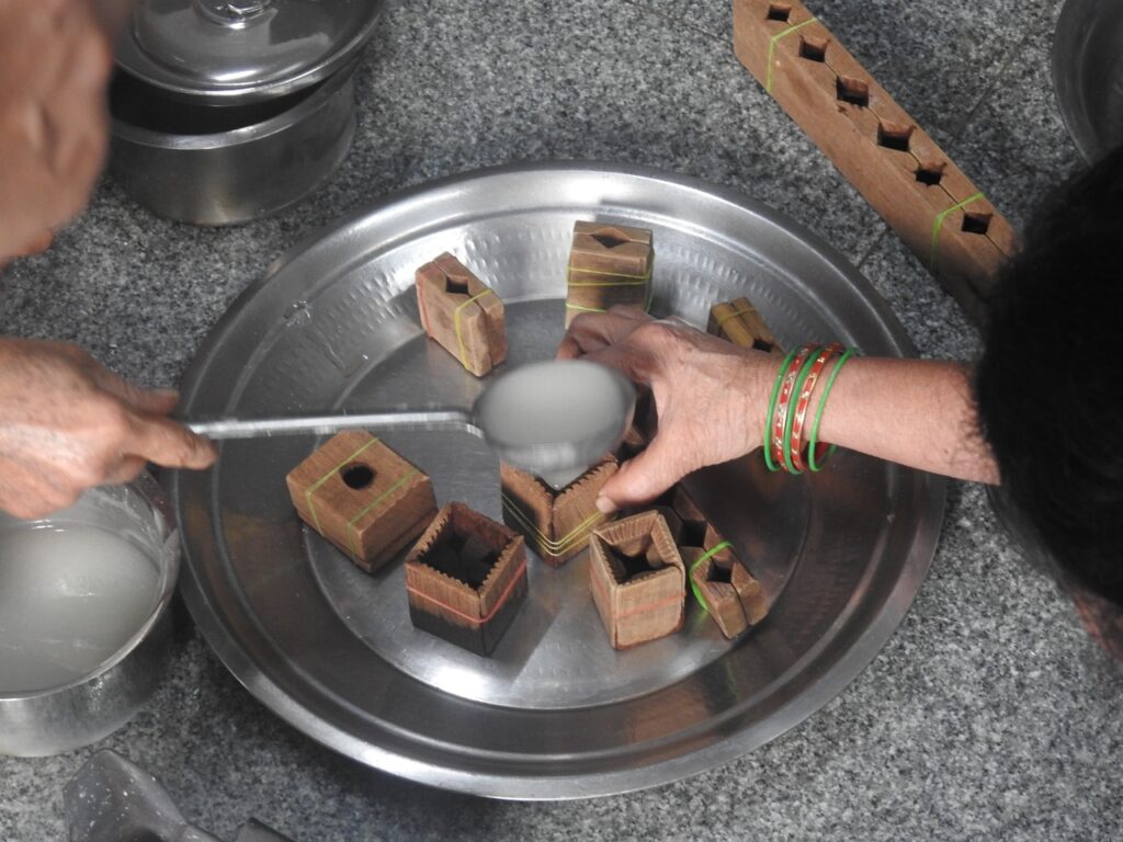 Pouring the sugar syrup into the mould of sakkare acchu